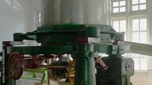 Grinding machine twisting crushing cut tea leaves on tea factory. Tea production, food industry concept. Tea manufacturing on industrial equipment. Workshop with large windows on plant.