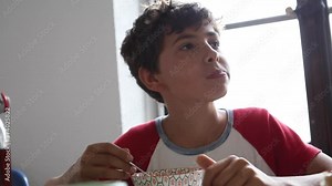 Preteen boy eating breakfast cereal in the morning breakfast