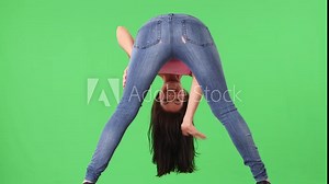 Back view of young woman in tight jeans bending over and smiling