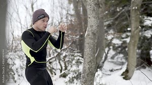 Young man shadow boxing in a forrest in Austria in the winter