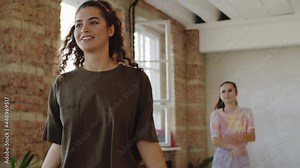 Young Caucasian woman dancing between afro-american and middle eastern men during group dance class in studio