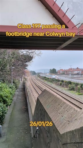 class 197 passing a footbridge