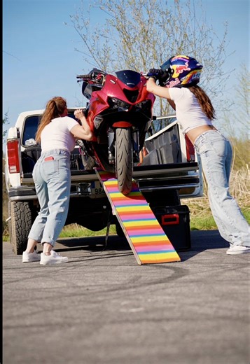 Two Girls Loading a Bike into a Pickup Truck