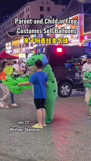 Parent and child in frog costumes sell balloons while the naughty child takes the opportunity to make trouble but is kissed gently .#chinatiktok