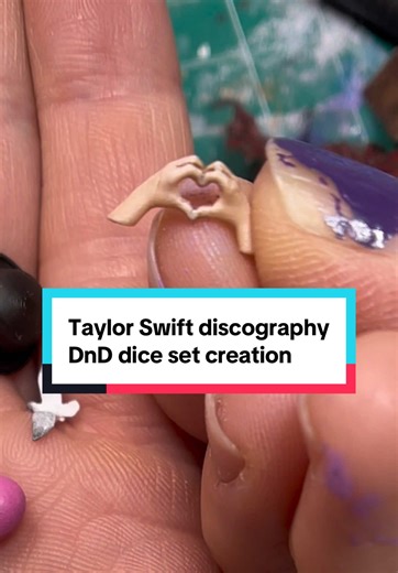 Because I didn’t do a good job of explaining it in the video, here are all the inclusions for each of the dice and what album they are for D4: red- black hat from the Eras tour and a red cloud D6: 1989- five seagulls and a blue cloud D8: fearless- heart hands and a golden cloud D10: folklore/evermore -flannel and lichen D10: lover- pink heart and blue and yellow clouds D12: reputation- red and gold painted snake shed D20: speak now- purple castle and purple sparkly cloud To all the people who re