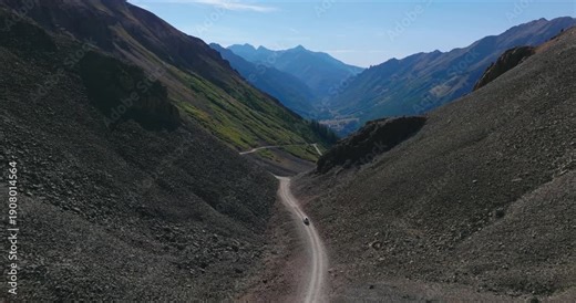 Ophir Pass descends steep alpine valley, rocky talus and scree slopes with sparse vegetation, aerial dolly
