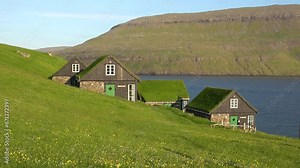 FAROE ISLANDS - JULY.16.2023 - Lakeside homes on the Faroe Islands have grass roofs.