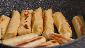 Traditional Eastern European cheese rolls or pancakes with filling, made from simple dough filled with cheese and meat, herbs and spices, fried until golden brown in pan.