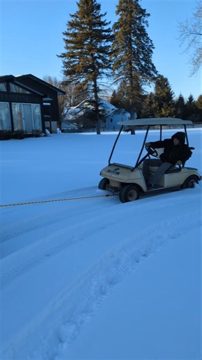 Pulling a golf cart through the snow