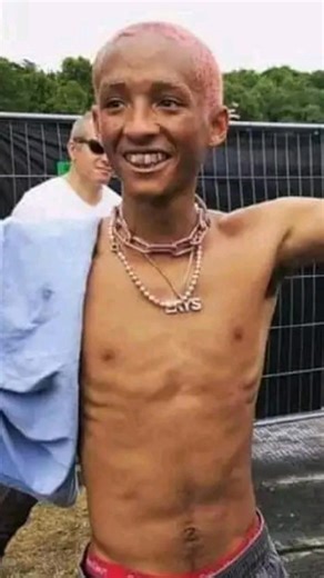 This image highlights the transformation of actor and musician Jaden Smith from his breakout role in 2010 to his later aesthetic. Then (2010): Jaden Smith starred as Dre Parker in the film "The Karate Kid," a role that required intense martial arts training. Now (2026): The image showcases his evolution into a musician and actor known for his unique fashion sense and creative projects. Context: The comparison reflects a significant journey in his career and public persona over sixteen years. | K