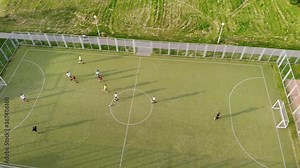 Shooting from a copter playing mini football in an open area in the green zone of the city. Camera in one position