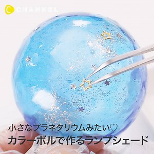 小さなプラネタリウムみたい♡カラーボールで作るランプシェード 💁C CHANNELのアプリではたくさんの動画が見られます🎶保存機能もありますので、ぜひ使ってみてくださいね💕 https://goo.gl/EJQTNy 暗い夜も足元を明るく照らしてくれるナイトランプ。お家で使っている人も多いのでは？ 今回はそのランプの光を、もっと素敵にできちゃうランプシェードの作り方です♡ 【用意するもの】 ・カラーボール ・竹串 ・グルーガン ・UV-LEDレジン 星の雫 Hard ・レジン着色剤 宝石の雫 (シアン、パープル) ・調色パレット ・調色スティック ・平筆 ・UVライト 9W ・極小ラメパウダー ・ラメ入りのマニキュア ・ミニメタル スター ・星型チャーム ・常夜灯（LEDタイプ） 【作り方】 1.カラーボールに竹串を刺し、空気が漏れないうちにグルーガンで密封する。 2.調色パレットでUVレジンと着色剤を混ぜて青、紫の色を作る。 3.カラーボールに平筆で青いレジンを塗りUVライトで硬化する。これを3〜4回 繰り返してドームを作る。この時、竹串の周りを適度に開けておくよう注意する。 