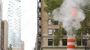 Steam vapor vented, New York City Church, Fulton street, orange vapour tube stack. Hot smoke pipe. Con Edison Steam Operations system, Manhattan downtown financial district architecture. Traffic light