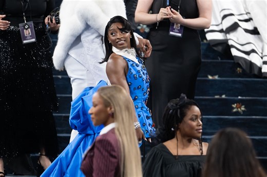 Simone Biles flaunts her GOAT pendant while donning red swimwear during her beach retreat