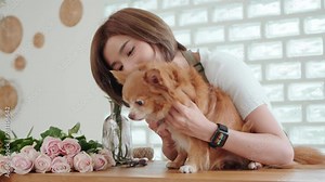 Florist lovingly cuddling her pet dog amid floral arrangements, highlighting a personal touch in her workspace