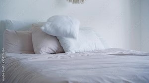 Throwing of white pillows on big bed in the morning. Unknown person adding clean bedding in bedroom. Relaxation, home, house. Stock Video