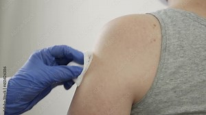 Tetanus shot. The doctor's hands make an injection with a syringe in the shoulder. Preservation of health and safety. Slow motion, close-up, HD.