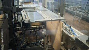 Industrial production line in modern factory. Forming a cardboard box on a conveyor. Close-up of an automated cardboard box machine in a modern factory. Modern workshop at a dairy plant. Cardboard box