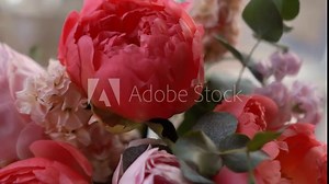 a beautiful bouquet of pink fragrant peonies and petals stands in a vase near the window, floristry and aroma