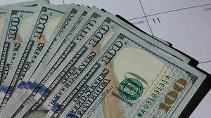 Stack of hundred dollar bills money fiat currency on table