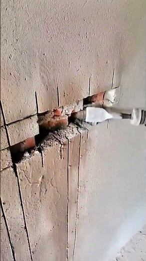 Cutting and chiseling a wall channel to install electrical conduit or wiring