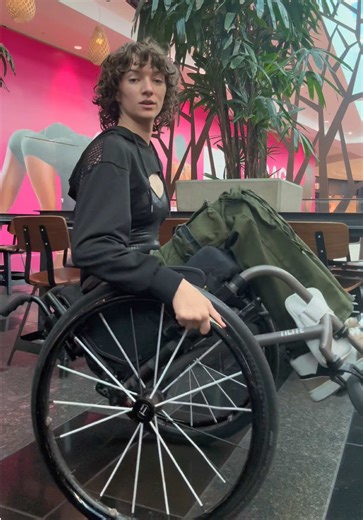 😊 Alt text: a woman in a wheelchair backs into frame, does a wheelie, smiles at the camera, twists to the left and right with her wheels, waves at the camera and ends the video. #Wheelie #WheelieGirl #Fun #Love #Random