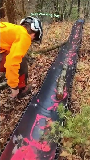 Transporting timber on a wooded slope using a cut corrugated pipe