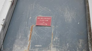 Slow Motion Pull Out from a Creepy Red No Deliveries Sign On an Abandoned Warehouse Door