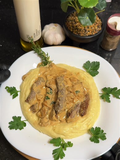 Steak with Creamy Mushroom Sauce and Mashed Potatoes Steak seasoned with salt and black pepper, seared in olive oil until 80% cooked, then finished with butter, garlic, and rosemary for rich flavor. Remove the steak and use the same pan. Sauté onions and mushrooms until nicely browned. Add garlic, a splash of soy sauce, and hot water or beef stock. Let it reduce slightly, then add cooking cream and parsley. Return the steak to the sauce for one minute to absorb the flavor. Serve with smooth mash