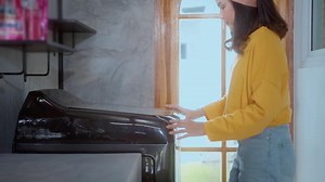 Download young woman washing with washing machine in her House for free