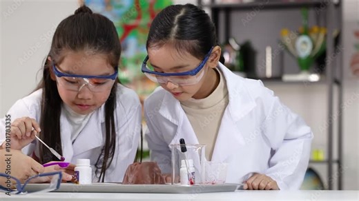 Asian Schoolgirls in Lab Coats Conducting Science Experiment with Volcano Model