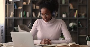 Diligent african student listen audio online course on laptop through headphones enjoy interesting remote study. University admission educational webinar, internet resources for self-education concept