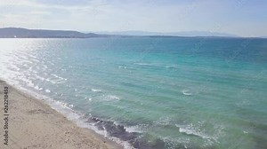 4K ascending drone shot, over Ilica Beach, wavy sea, sunny weather, water reflecting sun rays, idyllic place, peaceful, in ilica, cesme, izmir province, turkey
