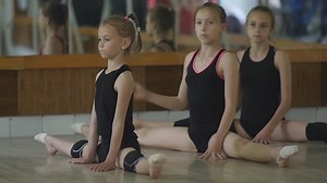 Young girls warm up in the gym. The exercises in rhythmic gymnastics.