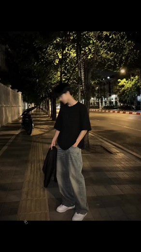 Cara membuat foto suasana jalan malam dengan efek gerak blur yang keren 1. Open the Dola app 📲 2. Upload your photo 📸 3. Copy and paste the prompt belowGambar ini adalah foto bergaya candid di malam hari yang menampilkan suasana jalanan perkotaan, dengan penggunaan efek motion blur yang sangat dominan pada subjeknya. Berikut adalah rincian detailnya: Subjek Utama: Di bagian bawah tengah hingga kanan gambar, terdapat seorang pria tampan yang sedang berdiri sambil sedikit menggerakkan rambutnya