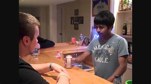 Magician performs a trick using a beer can in front of a drunk audience