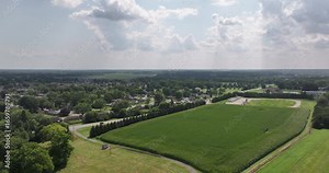 Aerial view of Xenia water tower, a vibrant blue structure amidst lush green fields and distant trees, casting a serene scene, Xenia, Ohio, United States.