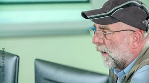 Grandpa is trying to learn together with hsi grandson. They are learning basic computer skills.