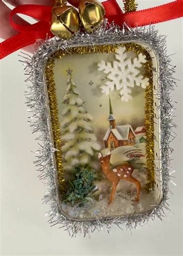 🦌 Shadowbox Ornament Reveal! ✨🦌❄️ Check out my new shadowbox ornament! This one features a vintage fawn in the snow with a Christmas card background of a snowy winter church scene. It's pure nostalgic holiday charm! Embellished with sparkly tinsel trim, a cheerful red bow, and little gold bells. 🎄💫 Find this unique piece of vintage-inspired decor in the shop!⬇️ | BluKatDesign