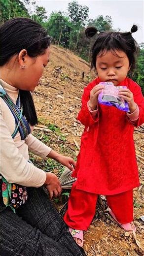 The little girl and her single mother eat candy with the baby.