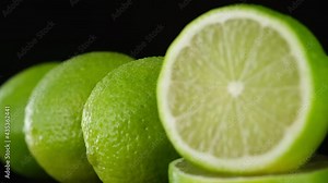 lime. close up of half and whole fresh limes. juicy limes isolated on black background. Sliding shot. 4K UHD video