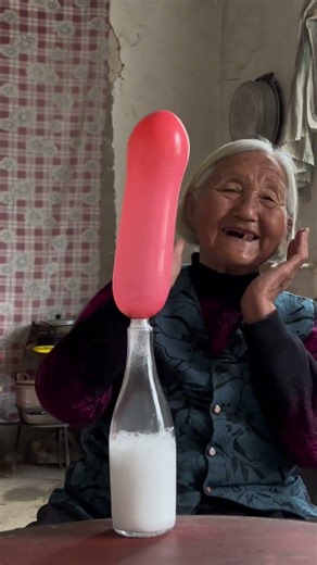 Blowing up balloons with a wine bottle—I blew one a bit too big, and it scared Grandma away.#grandma
