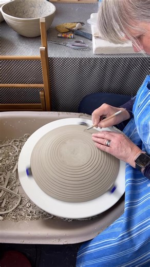 I’m working on some tall plates this week made in two parts, carved on the wheel, then finished with hand-coloured underglaze transfers. Once fired, I glaze just the top section and leave the carved clay in its natural state. That mix of texture and shine is what always interests me. A popular piece in my range for cakes, shared food, or simply elevating everyday moments. #ceramics #clay #pottery #clayartist #studiopotter