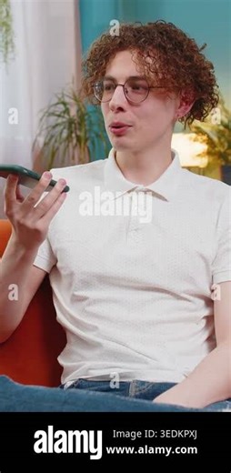 Happy Caucasian man making phone call conversation with friends at modern home room apartment. Young brunette guy enjoying mobile loudspeaker talking gossip, rumors, good news sitting on couch indoors Stock Video Footage - Alamy