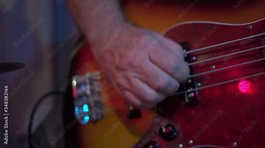 Close-up of a man hand playing the bass strings with a pick Stock Video