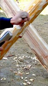 shaping a wooden joint into a triangular structure using a sharp hand axe for building outdoor