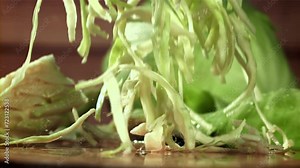 The shredded cabbage falls onto the cutting board. Filmed on a high-speed camera at 1000 fps. High quality FullHD footage