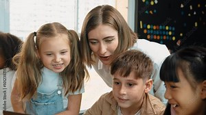 Caucasian teacher looking at african learner work or presentation. Group of diverse student looking at presentation while learning about coding and programing data at STEM technology class. Erudition.