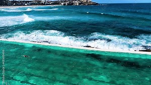 Bondi Beach Swimming Pool (Iceberg Pool). Showing Bondi Icebergs Pool, With People Swimming And People Surfing At Bondi Beach In The Background. Bondi, Sydney, Australia