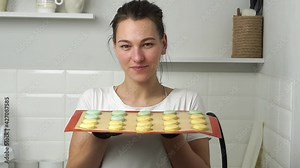 Making macaroons.Beautiful girl sniffs macaroni cakes.Macaroons